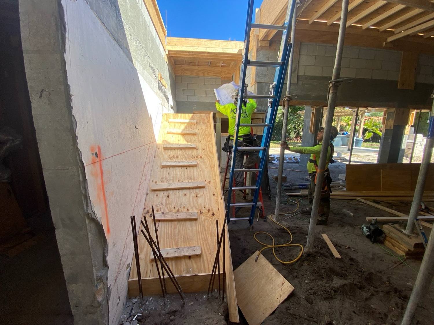 The custom stair in Pinecrest during construction, plywood treads and temporary framing