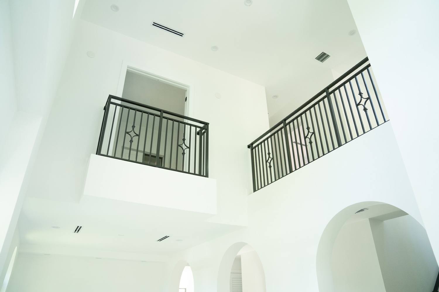 Two-story stair void with iron railings during construction