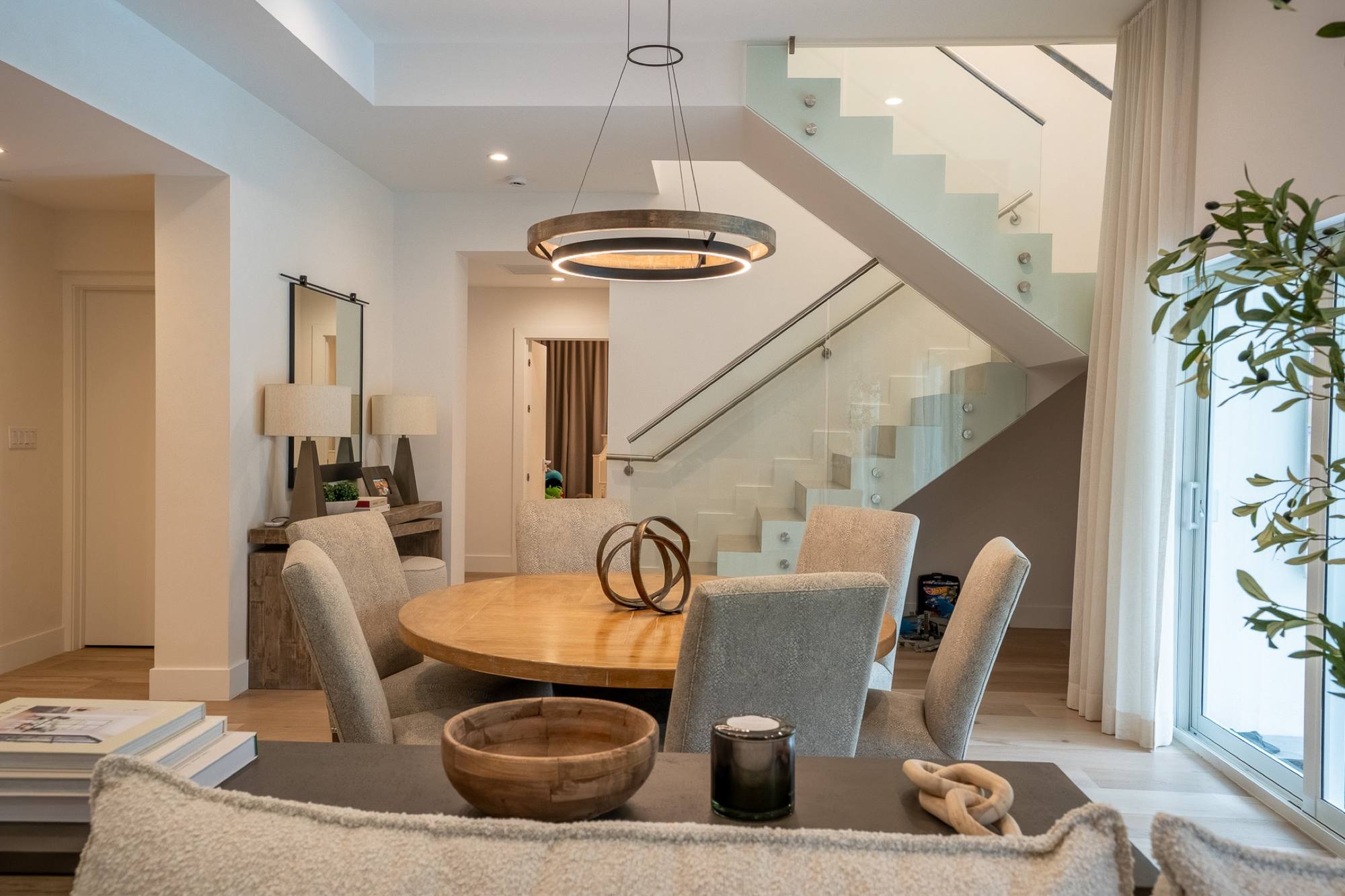 Custom staircase over a dining room with a ring pendant and pool view, Pinecrest