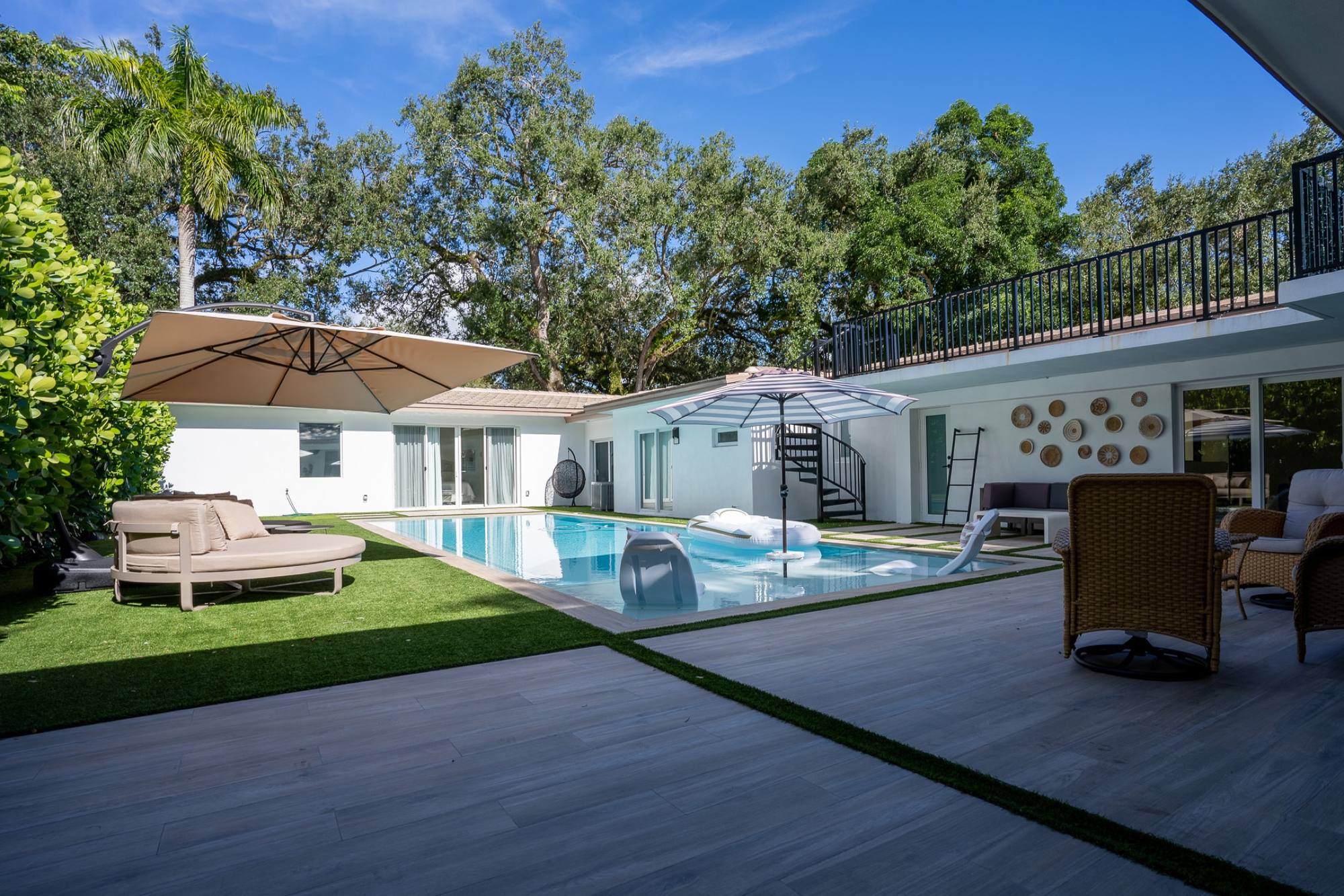 Courtyard swimming pool with a spiral stair up to the roof deck, seen from the terrace deck, Coral Gables