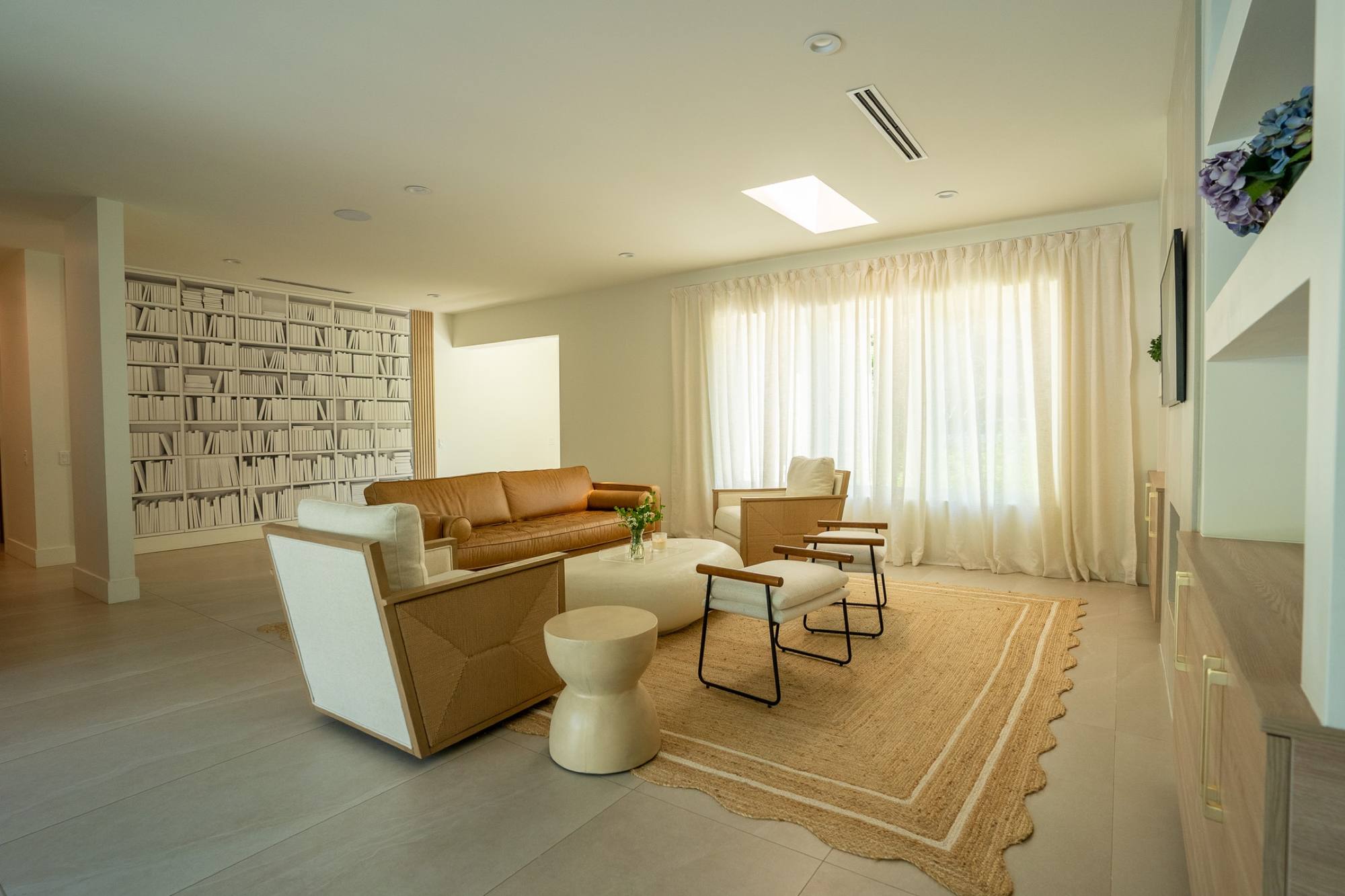 A finished kitchen island in a South Miami home, veined stone under pendant lights