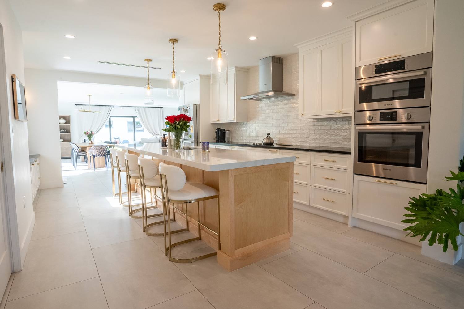 Kitchen island with stools and a pair of wall ovens